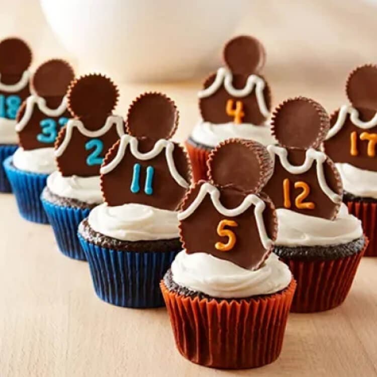 iced chocolate cupcakes with basketball themed toppers made from reese's cups